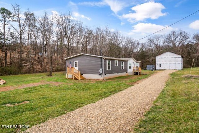 view of front of house with an outbuilding, crawl space, a front yard, and a garage