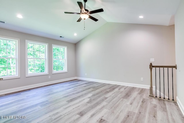 unfurnished room with light wood-type flooring, visible vents, and lofted ceiling