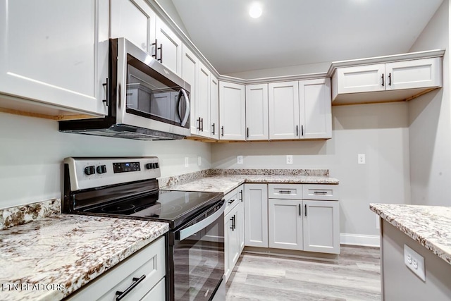 kitchen featuring stainless steel appliances, light wood finished floors, white cabinetry, and light stone countertops