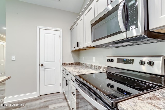 kitchen featuring light stone countertops, light wood-style flooring, white cabinetry, and stainless steel appliances