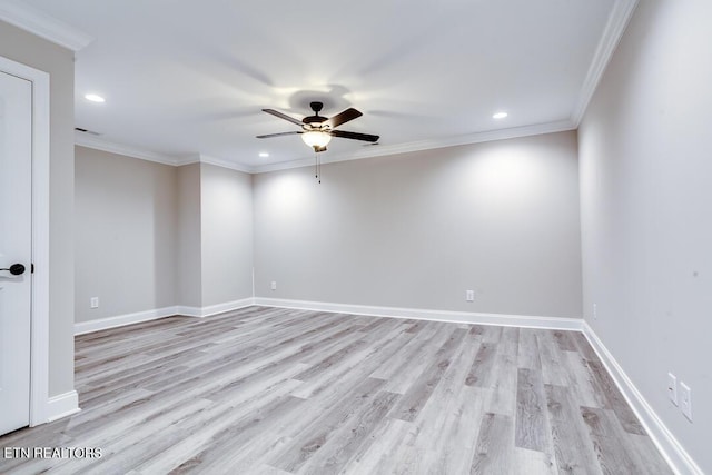 spare room with ornamental molding, light wood finished floors, and baseboards