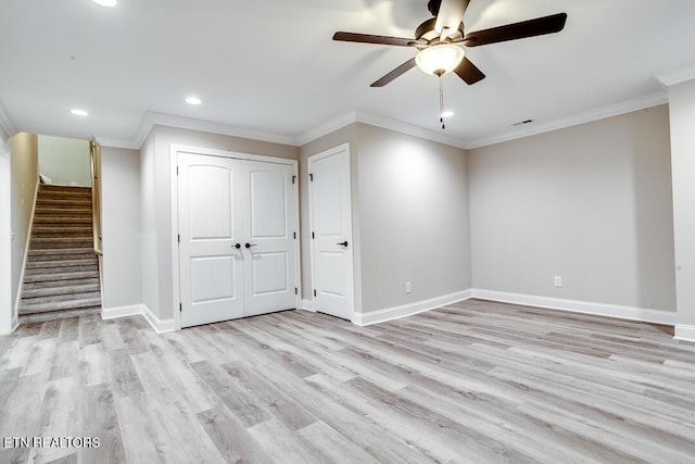 unfurnished room featuring ornamental molding, stairway, light wood-type flooring, and baseboards