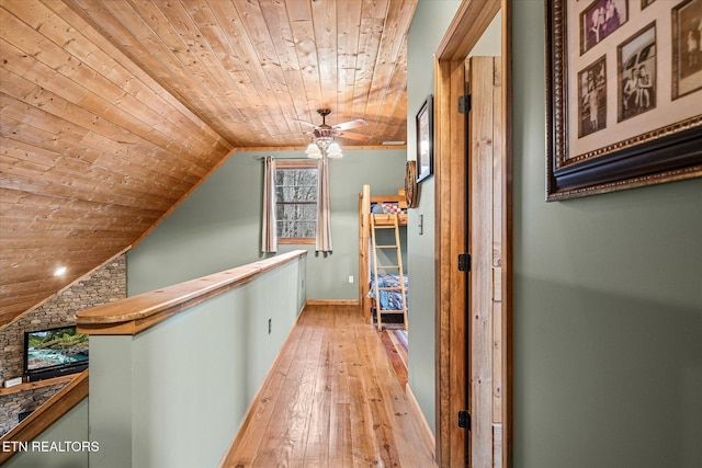 corridor featuring wood ceiling, light wood-style flooring, vaulted ceiling, and an upstairs landing