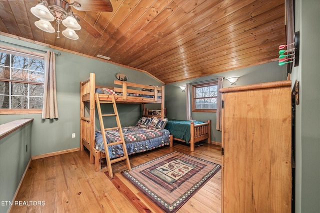 bedroom featuring lofted ceiling, light wood finished floors, wood ceiling, and baseboards