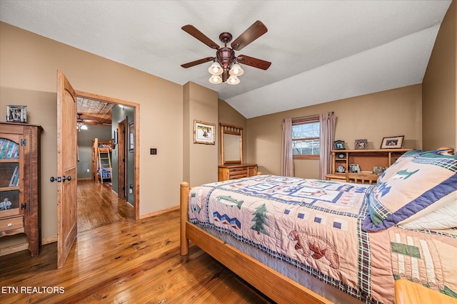 bedroom with vaulted ceiling, wood finished floors, a ceiling fan, and baseboards