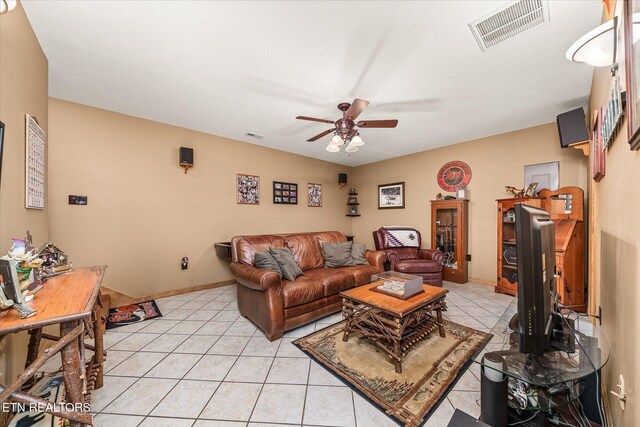 living room featuring a ceiling fan, visible vents, baseboards, and light tile patterned floors