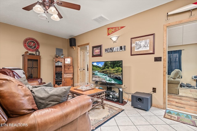 living area featuring light tile patterned floors, ceiling fan, and visible vents