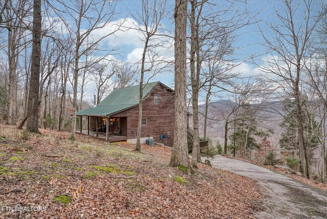 view of home's exterior featuring driveway, central AC unit, and a porch