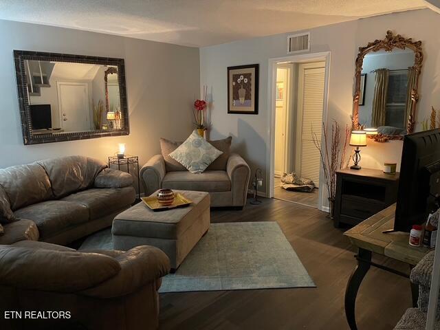 living area with wood finished floors and visible vents