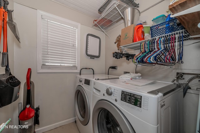 clothes washing area featuring laundry area, washing machine and dryer, and baseboards