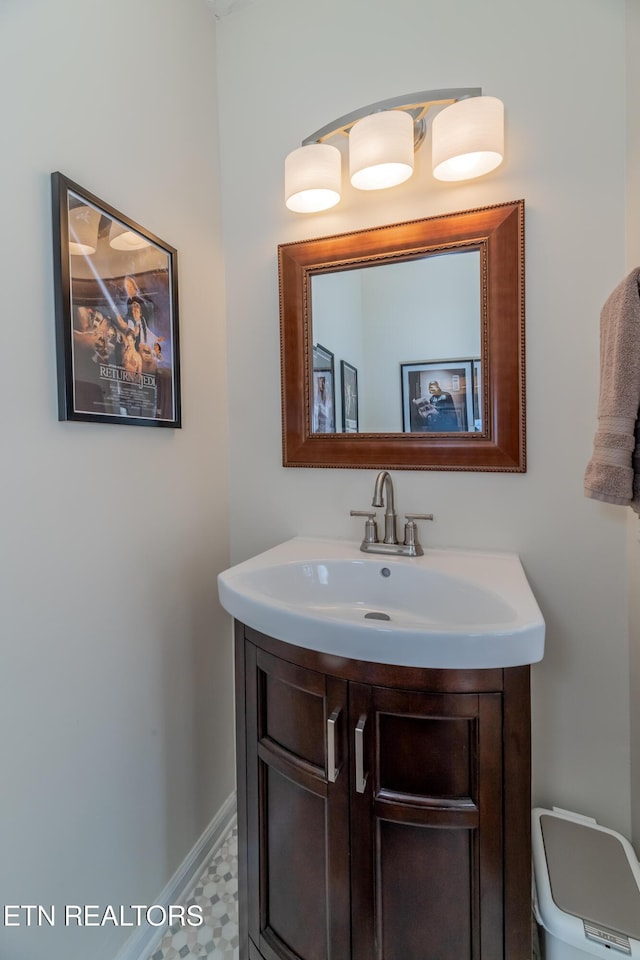 bathroom featuring toilet, baseboards, and vanity