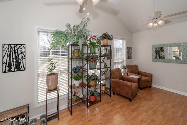 sitting room with lofted ceiling, wood finished floors, a ceiling fan, and baseboards