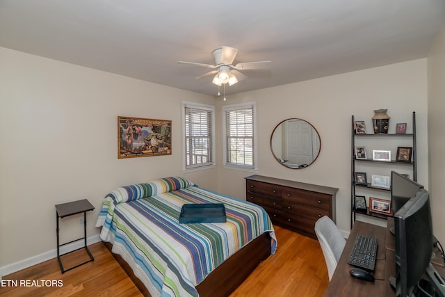 bedroom featuring ceiling fan, baseboards, and wood finished floors