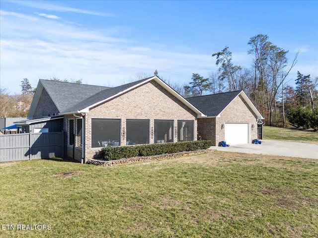 ranch-style house with a garage, brick siding, a front yard, and fence