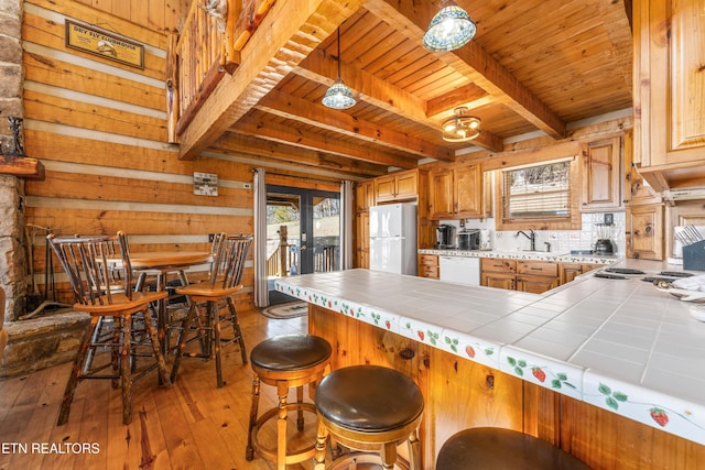 kitchen featuring white appliances, tile countertops, wood ceiling, light wood-style floors, and a sink