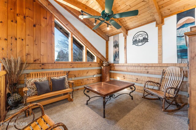 sitting room featuring wood ceiling, ceiling fan, vaulted ceiling with beams, carpet flooring, and wood walls