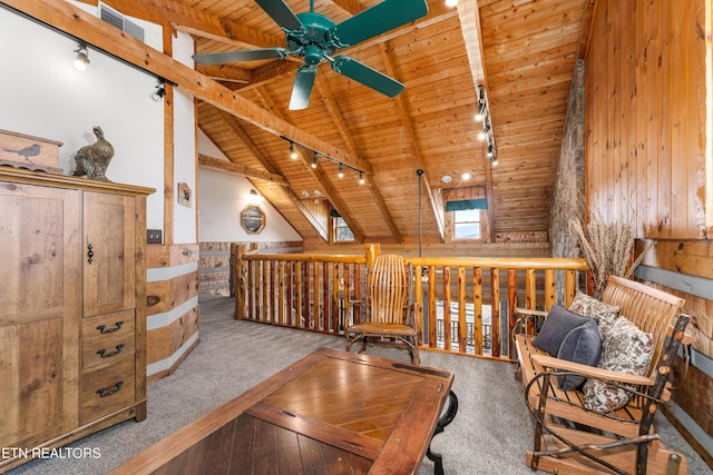 living area with carpet floors, beam ceiling, rail lighting, a ceiling fan, and wood ceiling