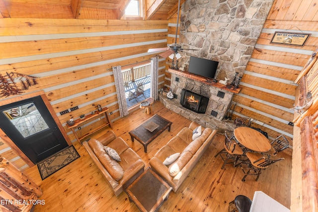 living area featuring wood walls, a fireplace, and wood-type flooring