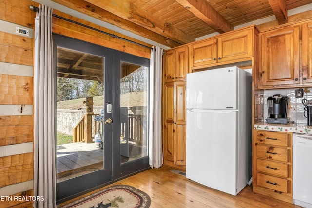 kitchen featuring french doors, light countertops, brown cabinetry, white appliances, and beamed ceiling