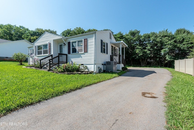 view of front of property featuring central AC, crawl space, a front yard, and fence