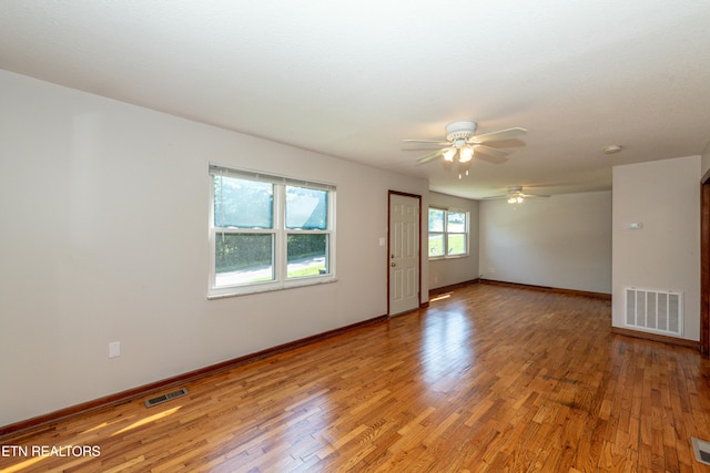 unfurnished room with light wood-type flooring, baseboards, and visible vents