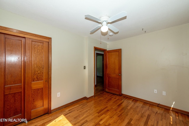 unfurnished bedroom with light wood-style floors, ceiling fan, and baseboards