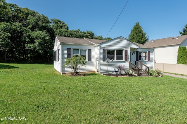 view of front of property with a front lawn and fence