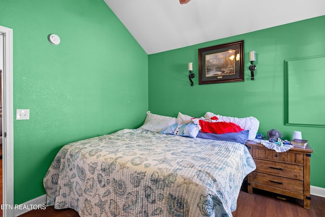 bedroom featuring lofted ceiling, wood finished floors, and baseboards