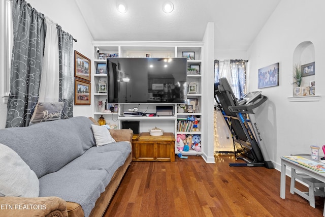 living area featuring lofted ceiling and wood finished floors