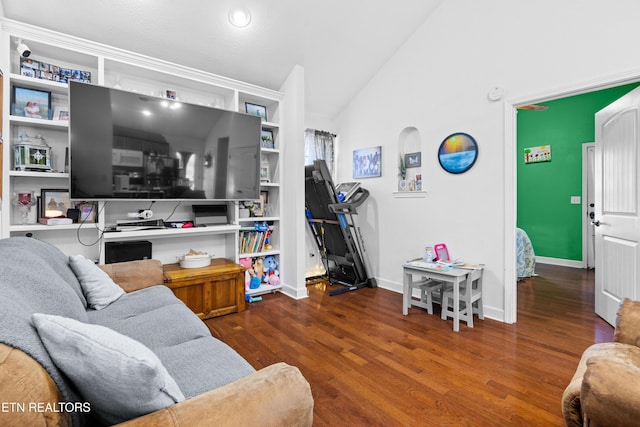living area featuring lofted ceiling, baseboards, and wood finished floors