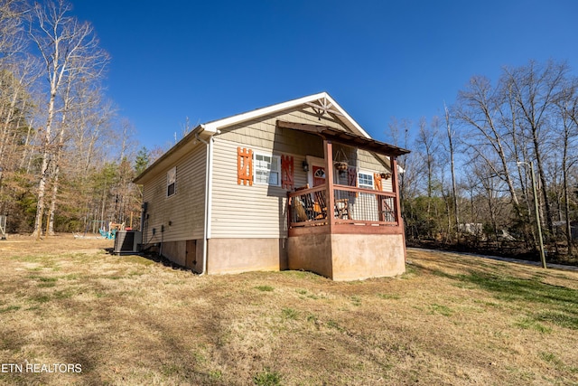 view of home's exterior featuring a lawn and central AC