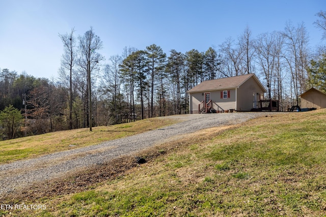 view of home's exterior featuring a yard and gravel driveway