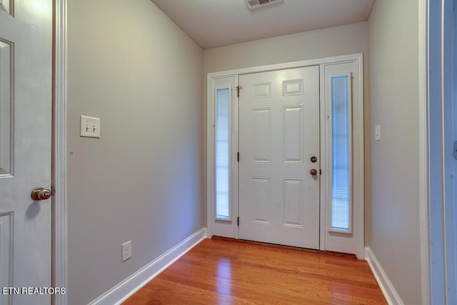 foyer featuring baseboards, visible vents, and light wood-style floors