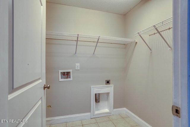 laundry area featuring washer hookup, light tile patterned floors, electric dryer hookup, laundry area, and baseboards
