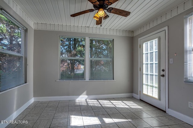 interior space with a ceiling fan, plenty of natural light, and baseboards