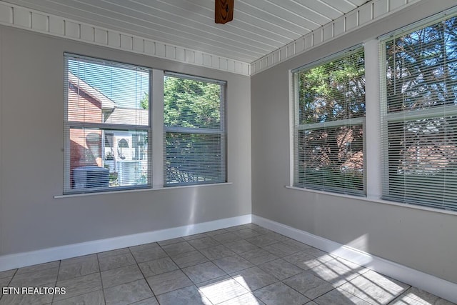 unfurnished room with a ceiling fan, baseboards, and tile patterned floors