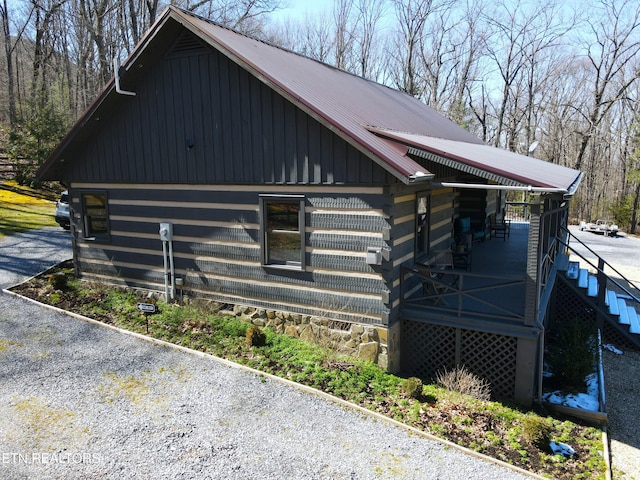 view of side of property featuring metal roof and stairway