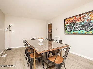 dining area featuring light wood-type flooring and baseboards