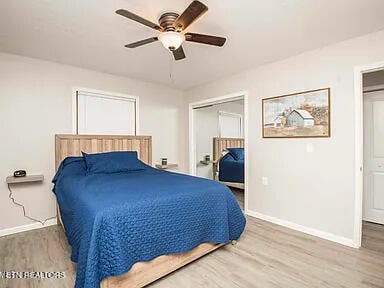 bedroom featuring wood finished floors, a ceiling fan, and baseboards