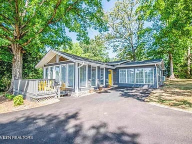 view of front of house featuring driveway, a sunroom, and a deck