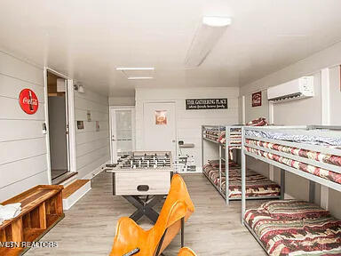 interior space with light wood-style floors and an AC wall unit