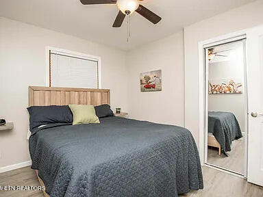 bedroom with ceiling fan, baseboards, and wood finished floors