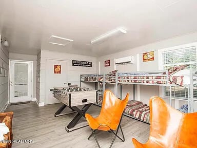 playroom with a wall mounted AC and wood finished floors