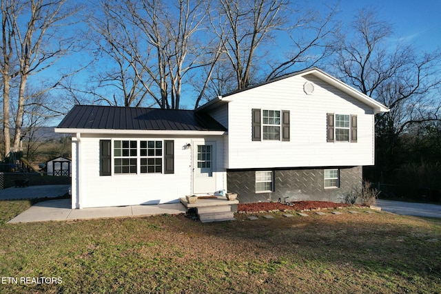 split level home featuring metal roof and a front lawn