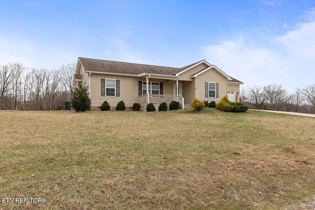 ranch-style house featuring an attached garage, a porch, and a front yard