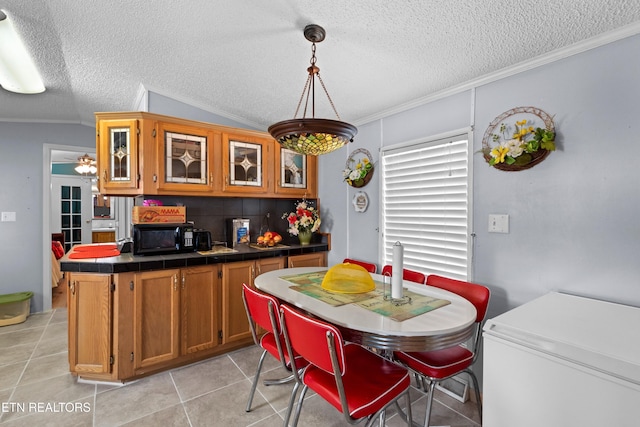 kitchen featuring brown cabinetry, tile countertops, glass insert cabinets, ornamental molding, and light tile patterned flooring