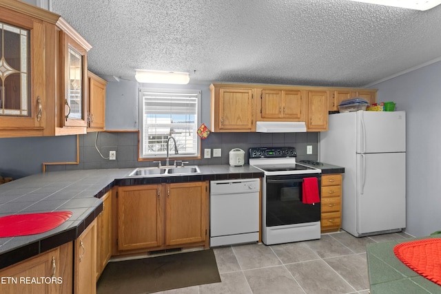 kitchen with tile countertops, tasteful backsplash, a sink, white appliances, and under cabinet range hood