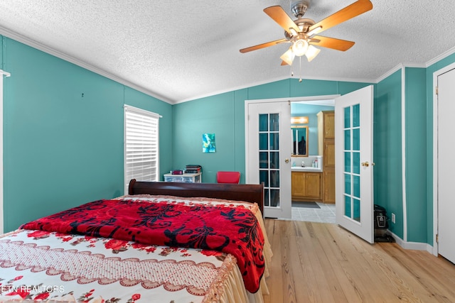 bedroom with lofted ceiling, light wood-style flooring, crown molding, and french doors