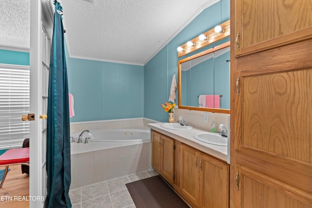 ensuite bathroom featuring tile patterned flooring, a textured ceiling, ornamental molding, and a sink