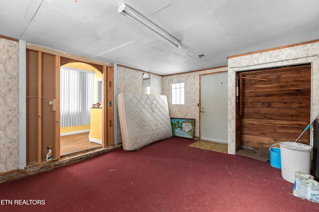 miscellaneous room featuring arched walkways and carpet flooring